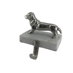 A sausage dog ornament attached to a block with hook for hanging Christmas stockings